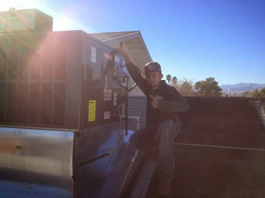 HVAC technician performing Heat Pump Repair on a rooftop unit in Stokesdale
